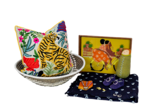 Brightly coloured artwork, a graphic print cushion and a ceramic bowl.