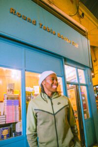 Caster Semenya smiling outside the Round Table Books Shop Front