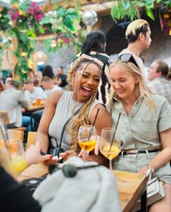 Women sitting outside in a rooftop bar drinking Aperol Spritz