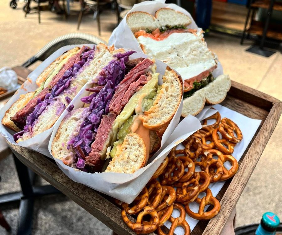 A beef bagel sliced in half, served with pretzels.