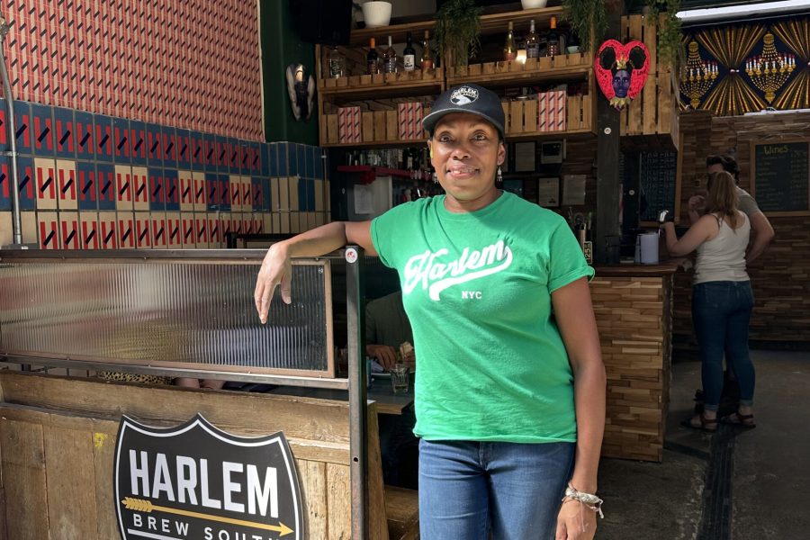 Celeste standing inside the taproom, leaning on the counter.