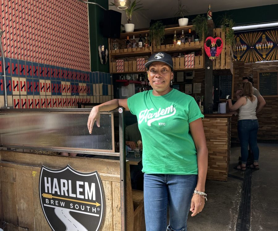 Celeste standing inside the taproom, leaning on the counter.