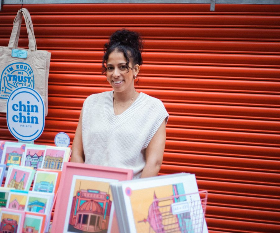 Woman standing behind a stall selling illustrations