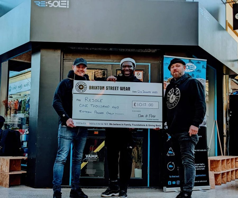 Three men standing holding a giant cheque